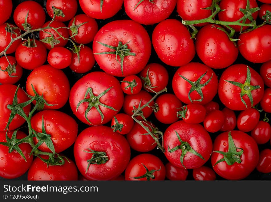 op view of ripe fresh tomatoes with water drops on black background
