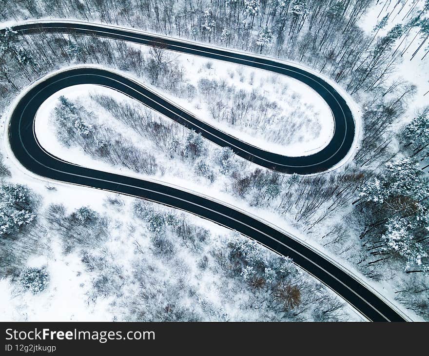 Curvy Winding Road Trough Forest at Winter Season. Aerial Drone Top Down View