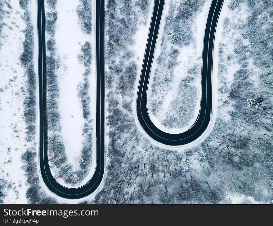 Curvy Windy Road In Snow Covered Forest, Top Down Aerial Drone View