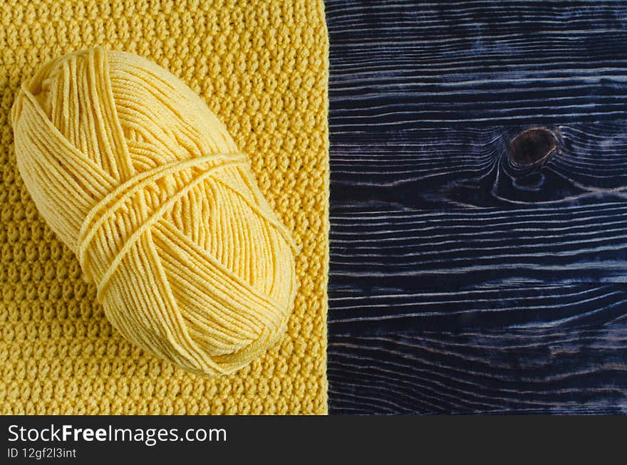 A Skein Of Yellow Yarn On A Background Knitted From Yellow Threads