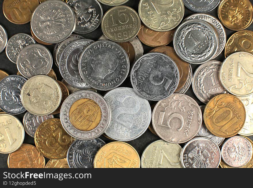 Many coins on a black background. Close-up