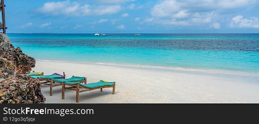 Tropical white beach with bench on Zanzibar island. Tanzania.