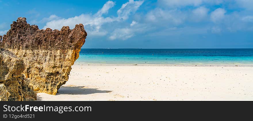 Panorama of a tropical white beach on Zanzibar island with a rock, Tanzania. Eastern Africa, copy space for text. Panorama of a tropical white beach on Zanzibar island with a rock, Tanzania. Eastern Africa, copy space for text