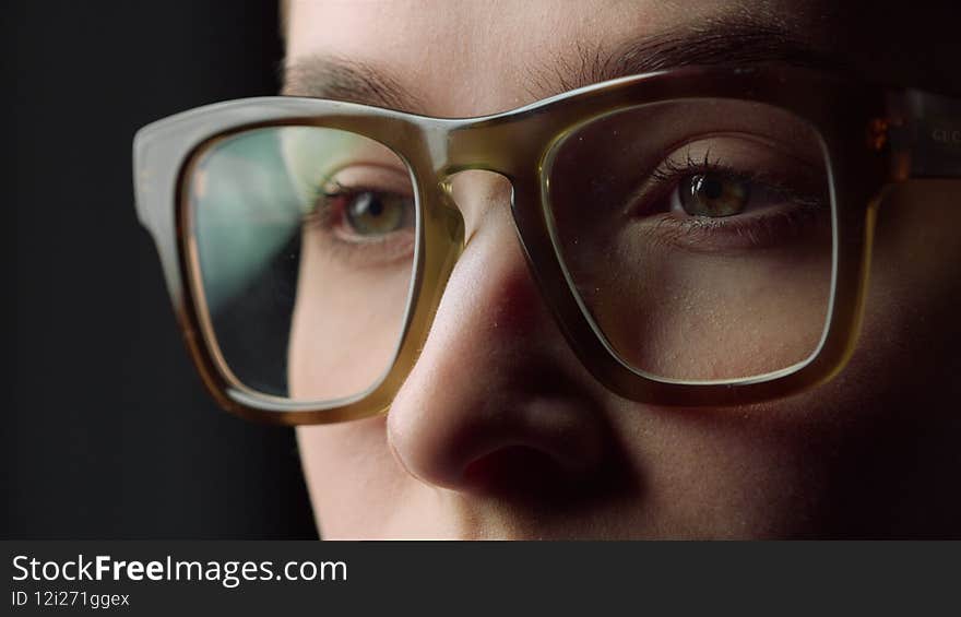 Portrait of tired student girl closing eyes in glasses in black studio. Concentrated young businesswoman working in front of screen. Exhausted female worker winking eyes indoors. Portrait of tired student girl closing eyes in glasses in black studio. Concentrated young businesswoman working in front of screen. Exhausted female worker winking eyes indoors.