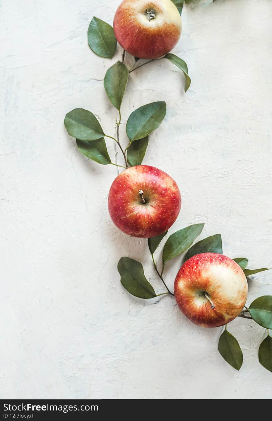 Fresh red apples with green leaves on white desk background. Top view