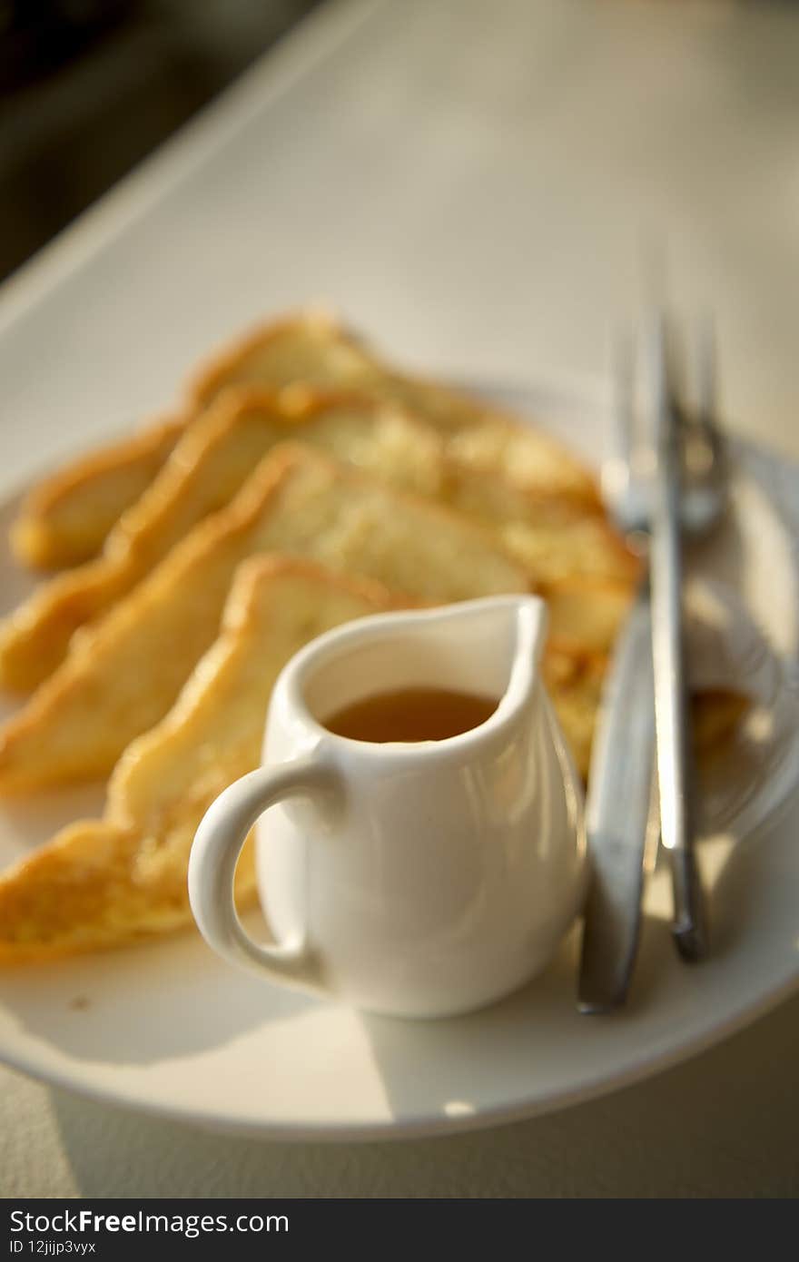 Vertical shot of french toast slices and maple syrup on a plate