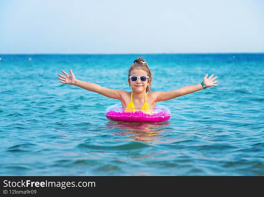The child swims in a circle in the sea. Selective focus.