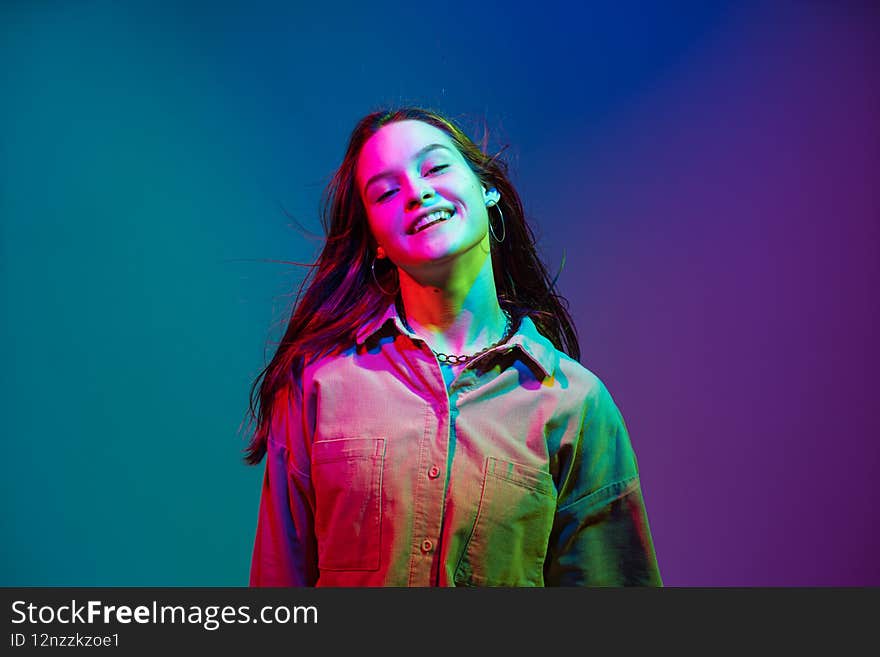 Smiling stylish young pretty girl with long waving healthy hairs laughing in colorful neon studio light. Creative woman beauty portrait. positive joyful emotions. High quality photo. Smiling stylish young pretty girl with long waving healthy hairs laughing in colorful neon studio light. Creative woman beauty portrait. positive joyful emotions. High quality photo