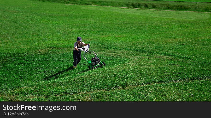 Lawn Mower. The worker cuts the lawn. Gardening and garden workers