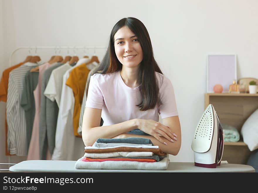 young housewife ironing clothes in the interior of the room. High quality photo
