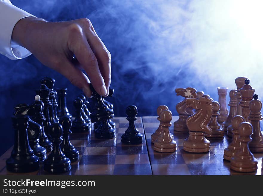 Hand of businessman moving chess pieces in a success game competition. Strategy, management or leadership concept