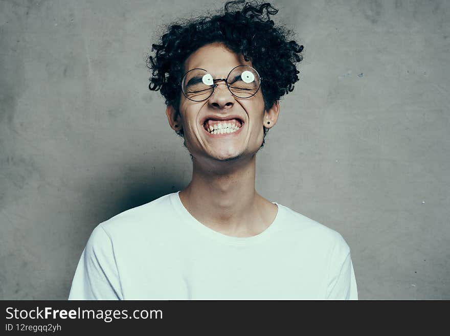 man with glasses curly hair white t-shirt studio emotion