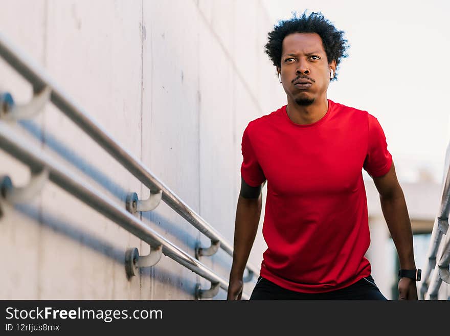 Afro athletic man doing exercise outdoors.