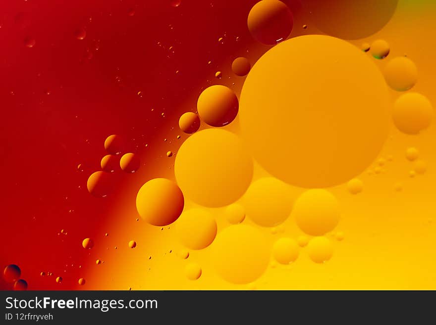 Macro photography of the oil drops on the water surface.Vibrant red and orange gradient.Cosmic circles looks like molecule