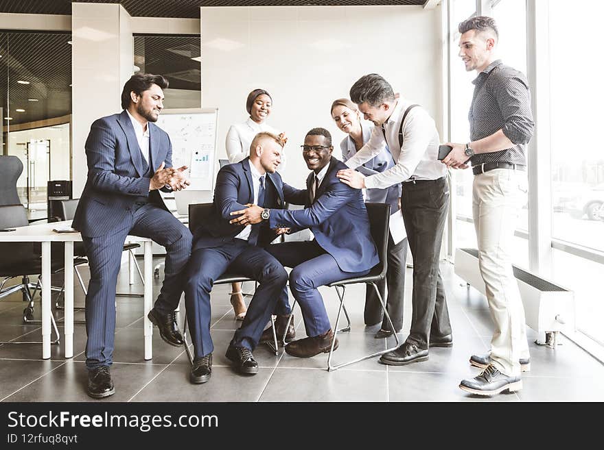 A team of young businessmen working and communicating together in an office. Corporate businessteam and manager in a