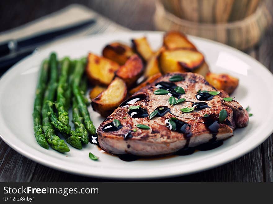 Fillet of beef with potatoes and asparagus on a plate.