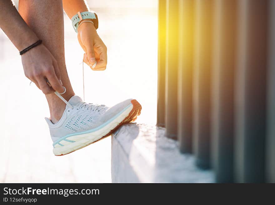 Sportswoman tying her shoelaces before going for a run.