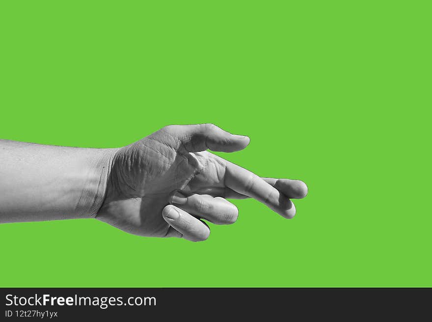 Black and white photography of male hand showing crossed fingers gesture,  a hand gesture commonly used to wish for luck, isolated on green background