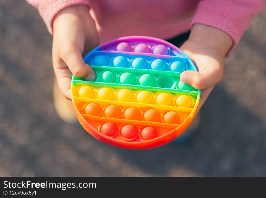 Colorful antistress sensory toy fidget push pop it in kid`s hands in children`s hands