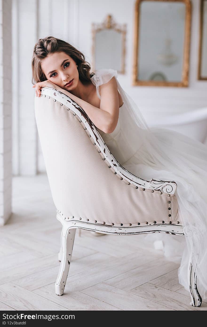 Beautiful Bride in wedding dress sitting in studio