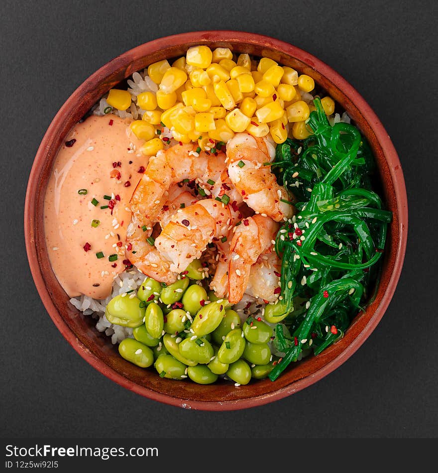 Hawaiian tuna poke bowl with vegetables on wooden background
