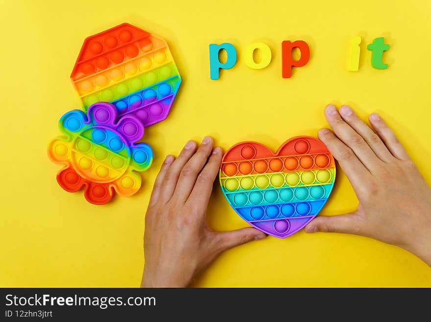 Colorful antistress sensory toy fidget push pop it. On a yellow background. Colorful antistress sensory toy fidget push pop it. On a yellow background