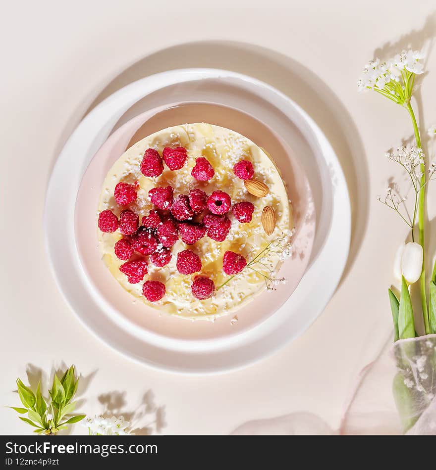 Home made, raspberry, almond cake on a white plate on a pink background. Sweet pastries with almond flour are gluten-free, low in carb. Keto diet. Healthy dessert. Flat lay