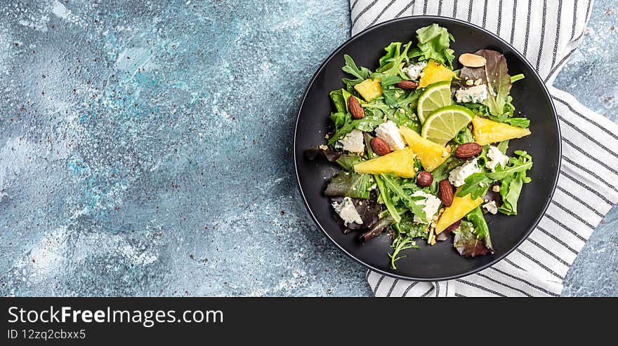 Healthy vegetable bowl lunch with salad of pineapple, blue cheese and almond. healthy and balanced food. banner, menu recipe place for text, top view.
