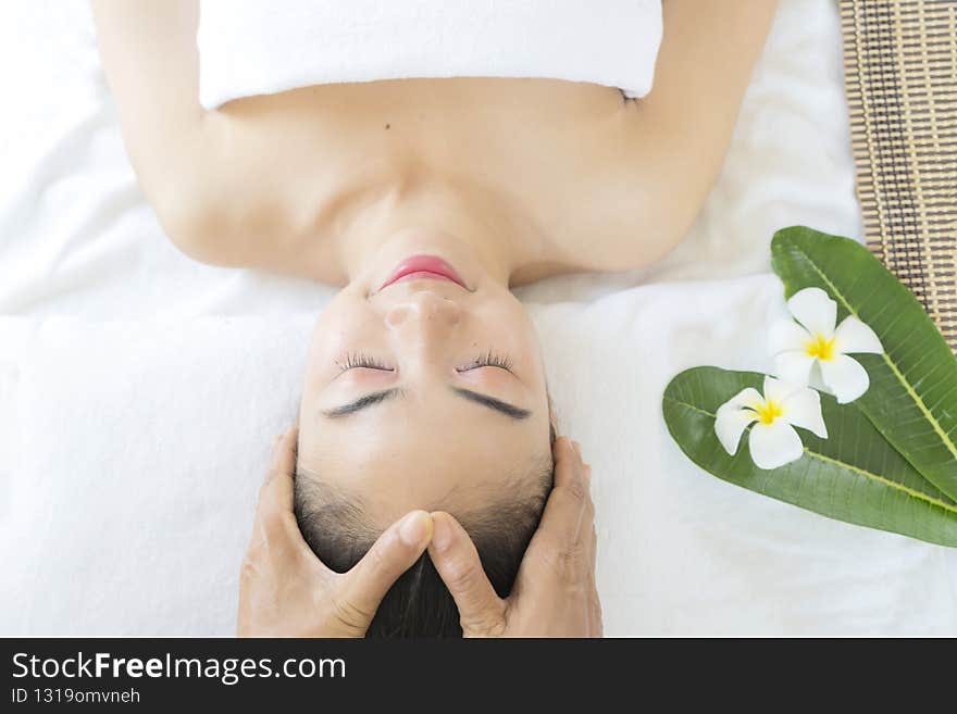 Beautician massaging woman`s face. Attractive girl having facial treatment and massage. The young woman is lying and relaxingin. Beautician massaging woman`s face. Attractive girl having facial treatment and massage. The young woman is lying and relaxingin