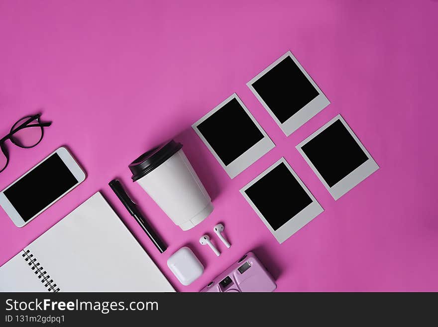 Mock up smart phone, earphone, notebook, cup and blank photo frame on pink background.