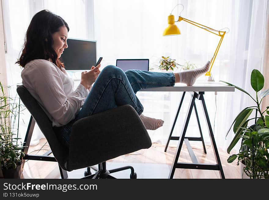 woman freelancer sitting at working place surfing internet on the phone copy space lifestyle