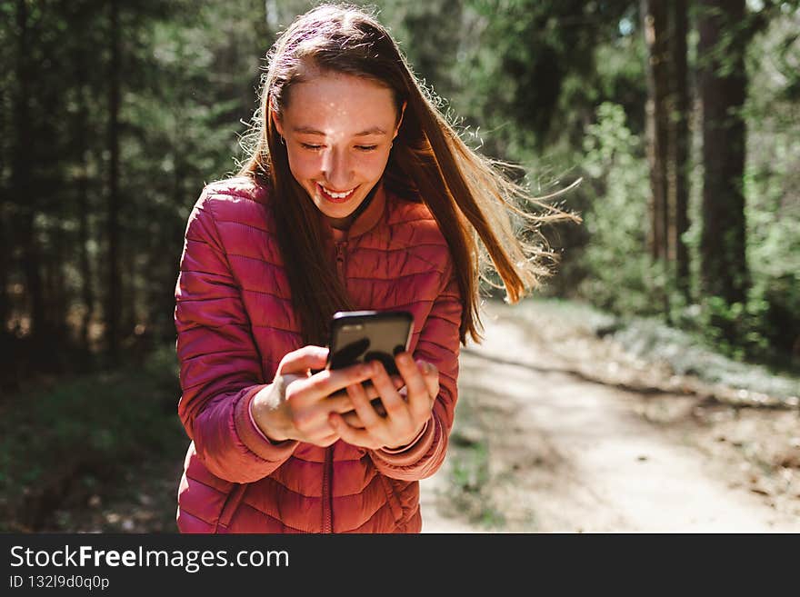 One 13s girl making a video call to her friend in the forest, Online communication concept.Nice sunny spring or summer day