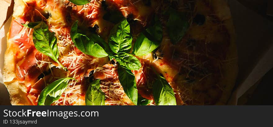 Appetizing delicious pizza. Close-up view of a piece of pizza with dark shadows. Food delivery. Pizza close up