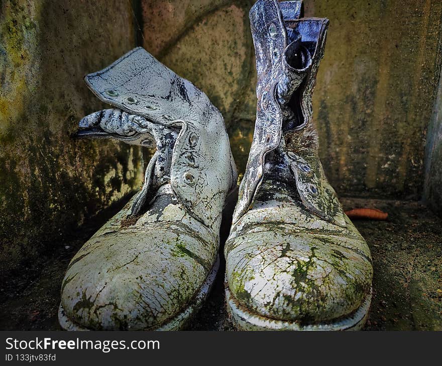 Army shoes that are worn, mossy and no longer used