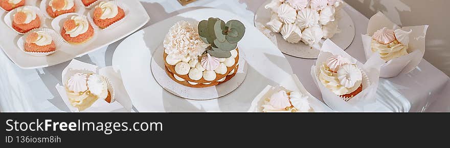 Candy bar at the banquet. Wedding table with sweets, cake, pastries, muffins, sugar treats. Event in the restaurant.