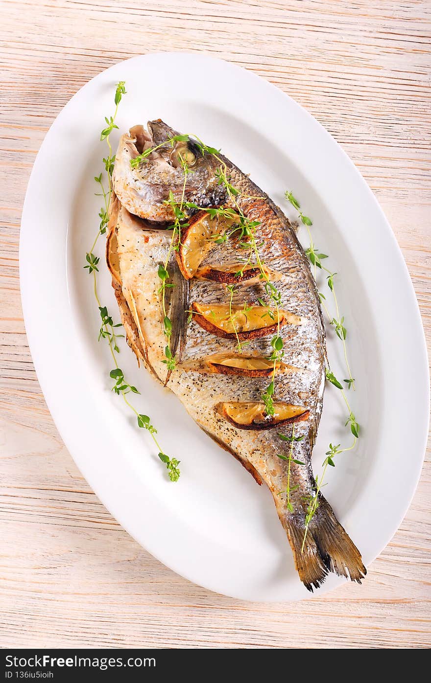Thyme and lemon baked sea bream fish on plate