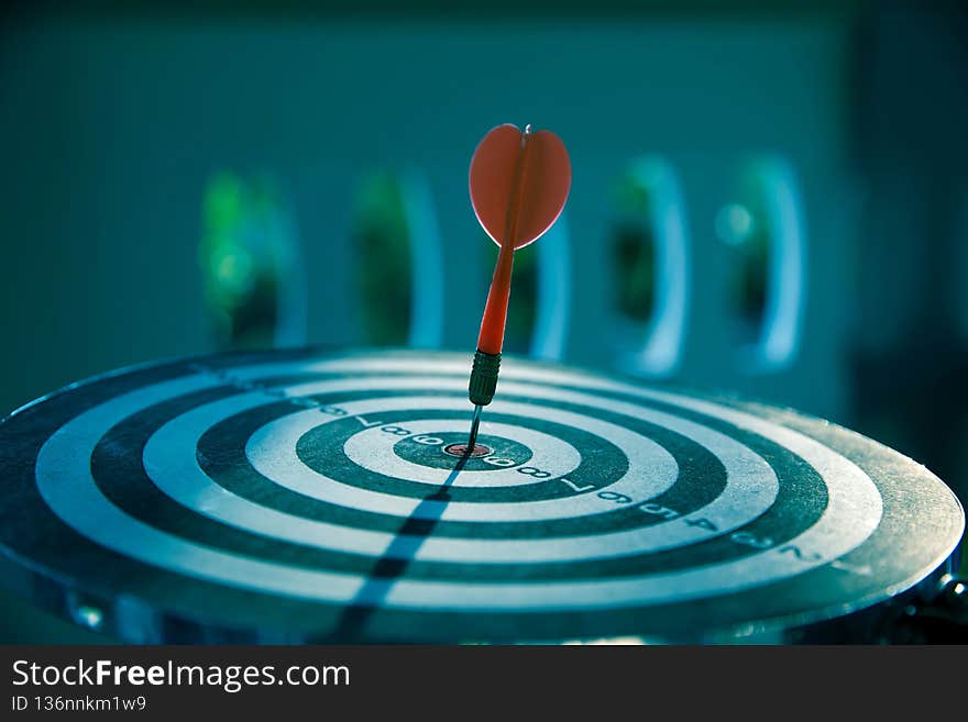 Bulls eye or bullseye target or dart board has red dart arrow throw hitting the center of a shooting for business target