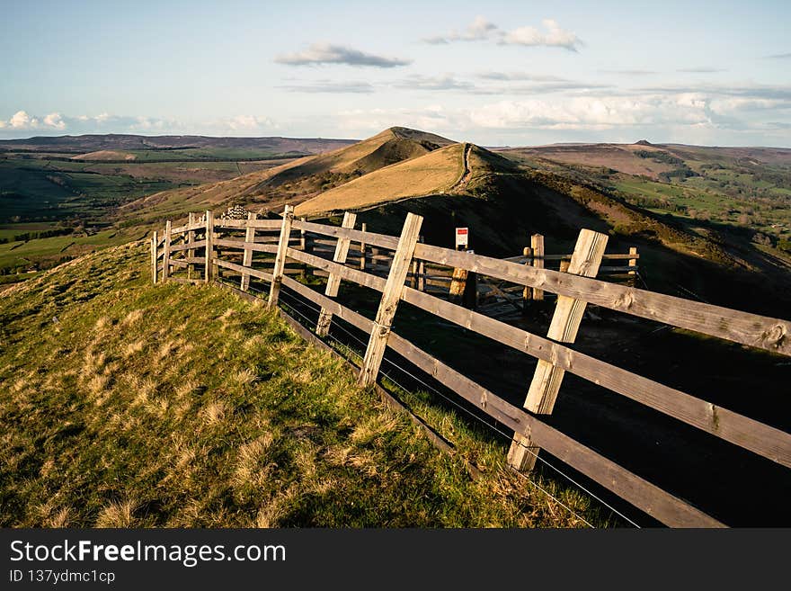 A close up of a hillside next to a wooden fence - Mam tor