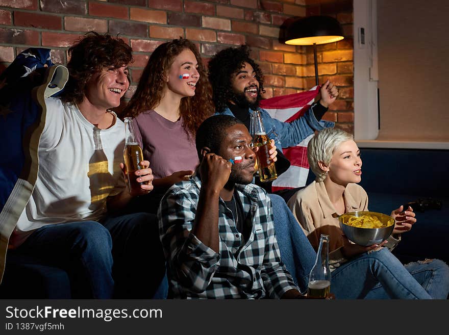 Excited young people watching sport match, chsmpionship at home, cheering for favourite national basketball, tennis, soccer, hockey team. Concept of emotions. Excited young people watching sport match, chsmpionship at home, cheering for favourite national basketball, tennis, soccer, hockey team. Concept of emotions.