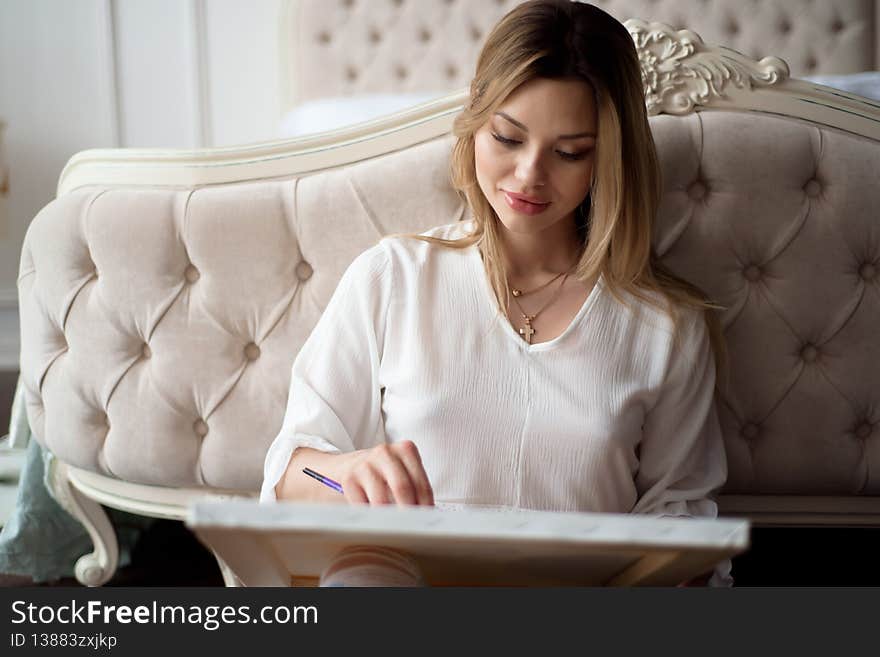 Beautiful woman artist drawing her picture on canvas with oil colors at home