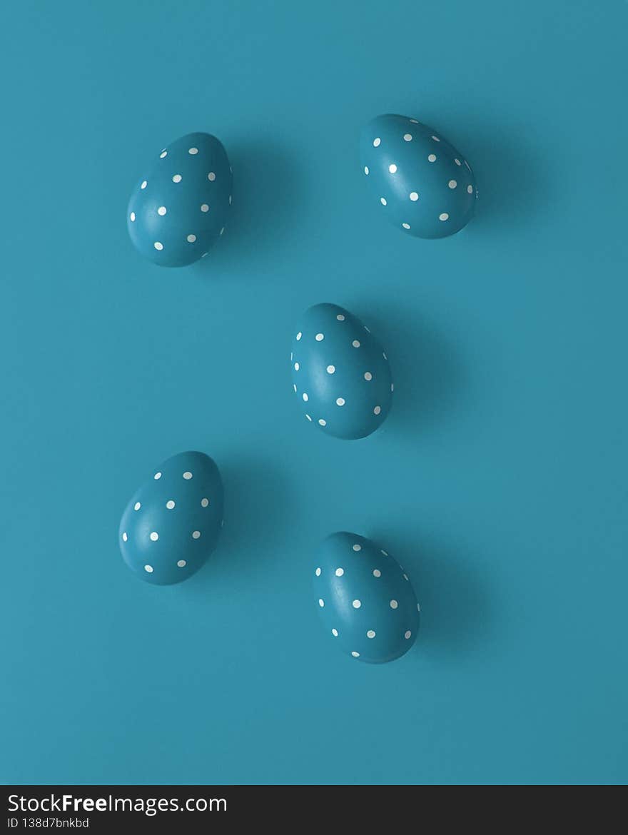 Blue punctate Easter eggs on blue background. Creative Spring concept, flat lay.