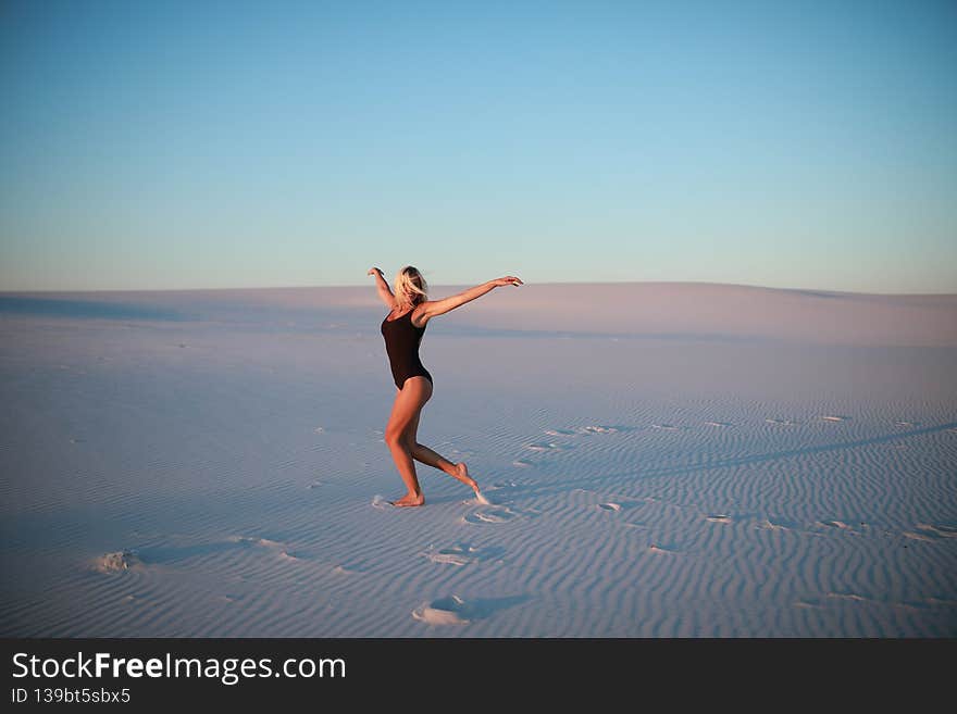 Beautiful blonde is resting on the sandy beach near the ocean