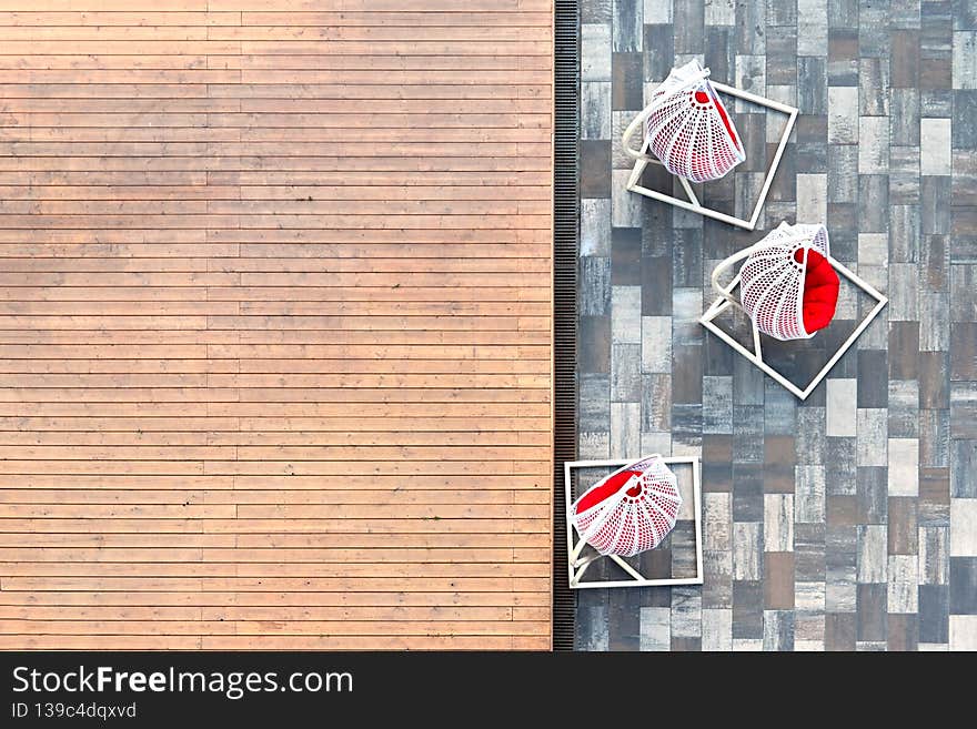 Suspended lounge chairs in white color stand in the inner city courtyard on gray paving, wooden plank flooring. The concept of a summer vacation in the city.Top view.