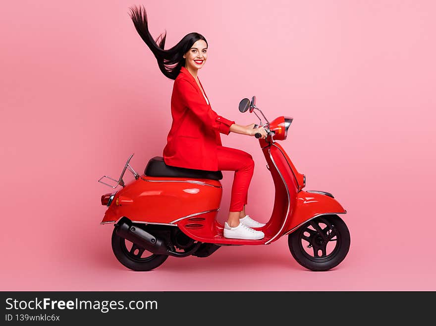 Full body profile side photo of young attractive woman happy positive smile driving red motorbike isolated over pink color background.