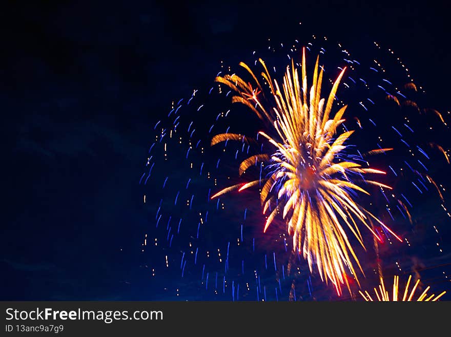 Fireworks on the background of the cloudy night sky. 4th of July - American Independence Day USA.