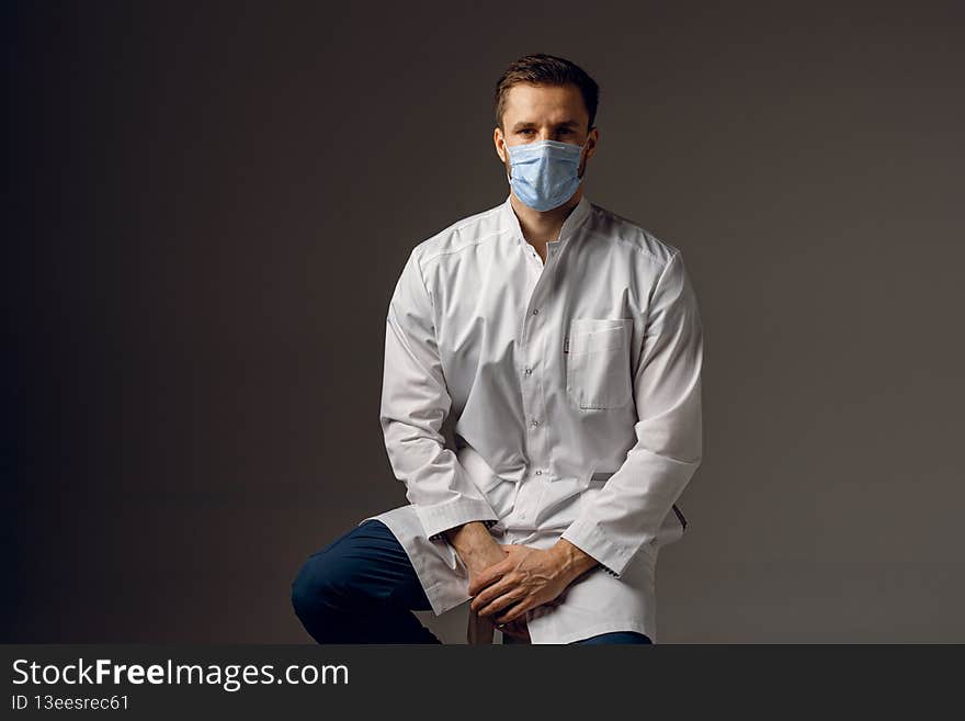Doctor in medical mask for protection against covid-19. Advices for protect health at 3rd wave of coronavirus. Handsome man weared in medical robe