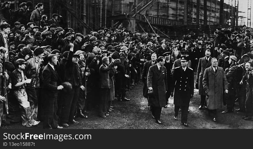 This is a Photograph of King George VI walking through the shipyard of John Readhead &amp; Sons Ltd, South Shields, flanked on either side by soldiers and workers, 7 April 1943.

Reference: 1061/1209/3

On 22 November Prince William will be visiting Sunderland and South Tyneside to take part in a number of youth development events.  During the visit he will also officially open Haven Point, the new leisure centre in South Shields.

To celebrate this Tyne &amp; Wear Archives has produced a short flickr set remembering past royal visits to the region’s shipyards.  Most of the visits featured here took place during difficult times and they gave a real boost to public spirits in the face of two World Wars.

A short blog relating to these images can be read  here .

These images are part of the Tyne &amp; Wear Archives Shipyard Collection. In July 2013 the outstanding historical significance of the Collection was recognised by UNESCO through its inscription to the UK Memory of the World Register.

&#x28;Copyright&#x29; We&#x27;re happy for you to share these digital images within the spirit of The Commons. Please cite &#x27;Tyne &amp; Wear Archives &amp; Museums&#x27; when reusing. Certain restrictions on high quality reproductions and commercial use of the original physical version apply though; if you&#x27;re unsure please email archives@twmuseums.org.uk. This is a Photograph of King George VI walking through the shipyard of John Readhead &amp; Sons Ltd, South Shields, flanked on either side by soldiers and workers, 7 April 1943.

Reference: 1061/1209/3

On 22 November Prince William will be visiting Sunderland and South Tyneside to take part in a number of youth development events.  During the visit he will also officially open Haven Point, the new leisure centre in South Shields.

To celebrate this Tyne &amp; Wear Archives has produced a short flickr set remembering past royal visits to the region’s shipyards.  Most of the visits featured here took place during difficult times and they gave a real boost to public spirits in the face of two World Wars.

A short blog relating to these images can be read  here .

These images are part of the Tyne &amp; Wear Archives Shipyard Collection. In July 2013 the outstanding historical significance of the Collection was recognised by UNESCO through its inscription to the UK Memory of the World Register.

&#x28;Copyright&#x29; We&#x27;re happy for you to share these digital images within the spirit of The Commons. Please cite &#x27;Tyne &amp; Wear Archives &amp; Museums&#x27; when reusing. Certain restrictions on high quality reproductions and commercial use of the original physical version apply though; if you&#x27;re unsure please email archives@twmuseums.org.uk