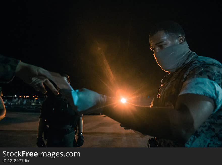 U.S. Marine Corps Cpl. Nestor Medina, a Manhattan, New York native and military policeman with Headquarters and Headquarters Squadron, Marine Corps Air Station Cherry Point, collects information from Marines and Sailors with 2nd Battalion, 6th Marine Regiment, 2d Marine Division, Marine Rotational Force-Europe 20.1, who returned from an overseas deployment in Norway at Marine Corps Air Station Cherry Point, North Carolina, April 24, 2020. The Marines and Sailors followed guidelines set by the Center for Disease Control and Prevention and the Department of Health and Human Service to take the necessary precautions to protect redeploying service members and mitigate the potential spread of COVID-19.  &#x28;U.S. Marine Corps photo by Lance Cpl. Patrick King&#x29;. U.S. Marine Corps Cpl. Nestor Medina, a Manhattan, New York native and military policeman with Headquarters and Headquarters Squadron, Marine Corps Air Station Cherry Point, collects information from Marines and Sailors with 2nd Battalion, 6th Marine Regiment, 2d Marine Division, Marine Rotational Force-Europe 20.1, who returned from an overseas deployment in Norway at Marine Corps Air Station Cherry Point, North Carolina, April 24, 2020. The Marines and Sailors followed guidelines set by the Center for Disease Control and Prevention and the Department of Health and Human Service to take the necessary precautions to protect redeploying service members and mitigate the potential spread of COVID-19.  &#x28;U.S. Marine Corps photo by Lance Cpl. Patrick King&#x29;