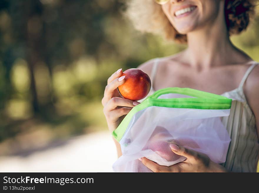 Nectarine. A picture of a young woman with a nectarine in her hand