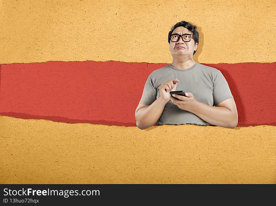 Asian man in eyeglasses with unhappy expression